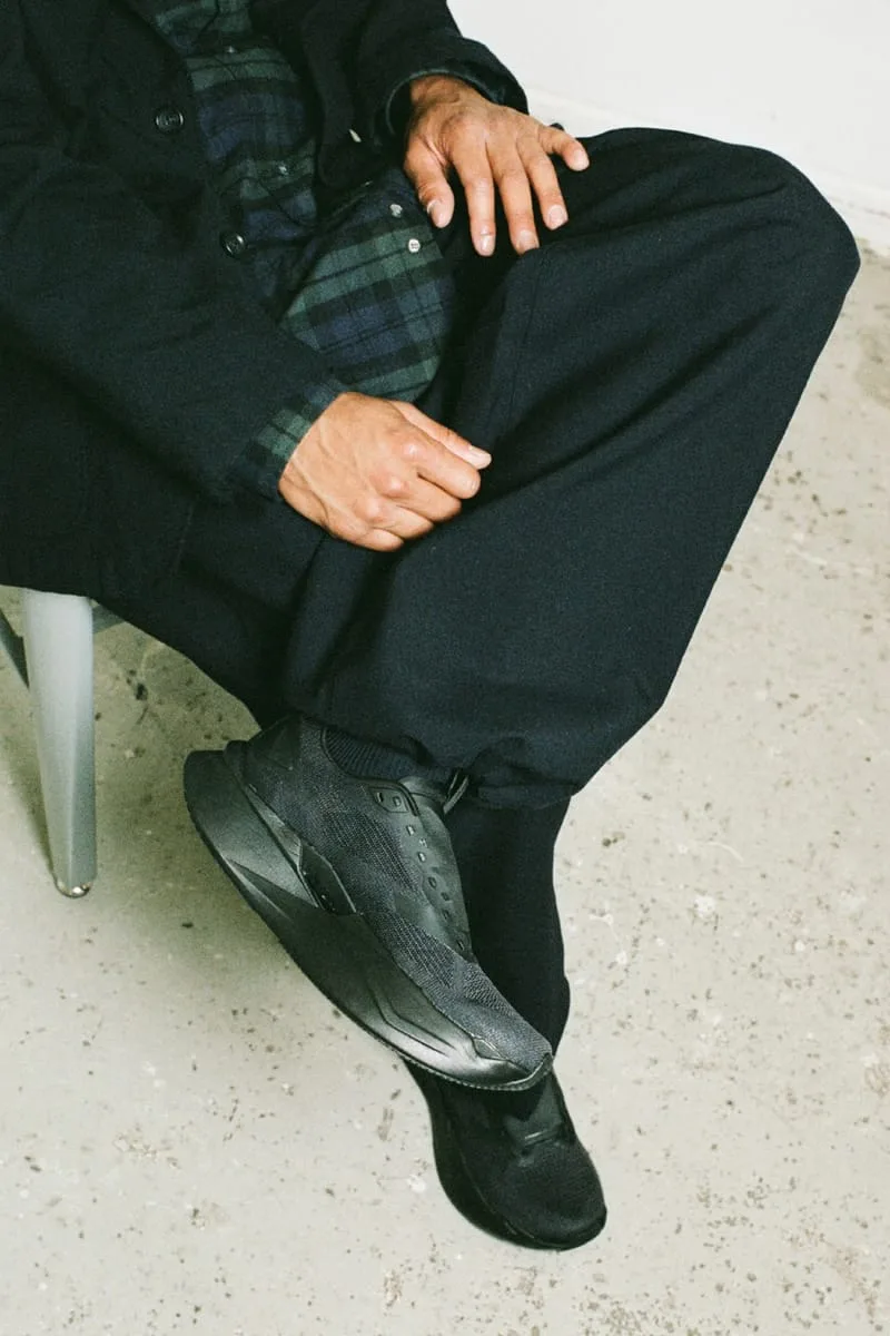 on-foot detail of man seated, black shoe by leg with black-and-green plaid cuff, Garments VECTIV Forward