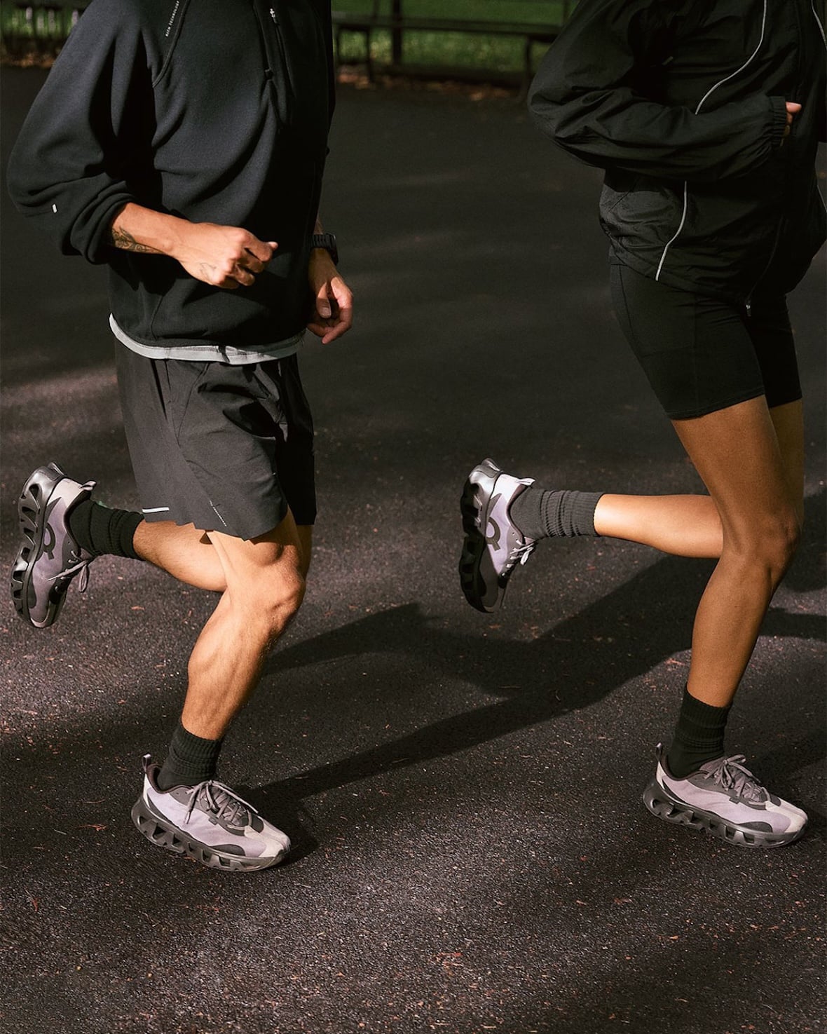 on-foot close-up of two runners' legs in grey/lilac pairs on asphalt, K Tech 3