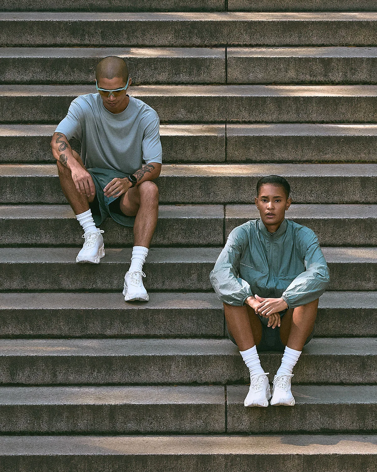 on-foot, two people seated on concrete steps wearing white pairs, K Tech 3