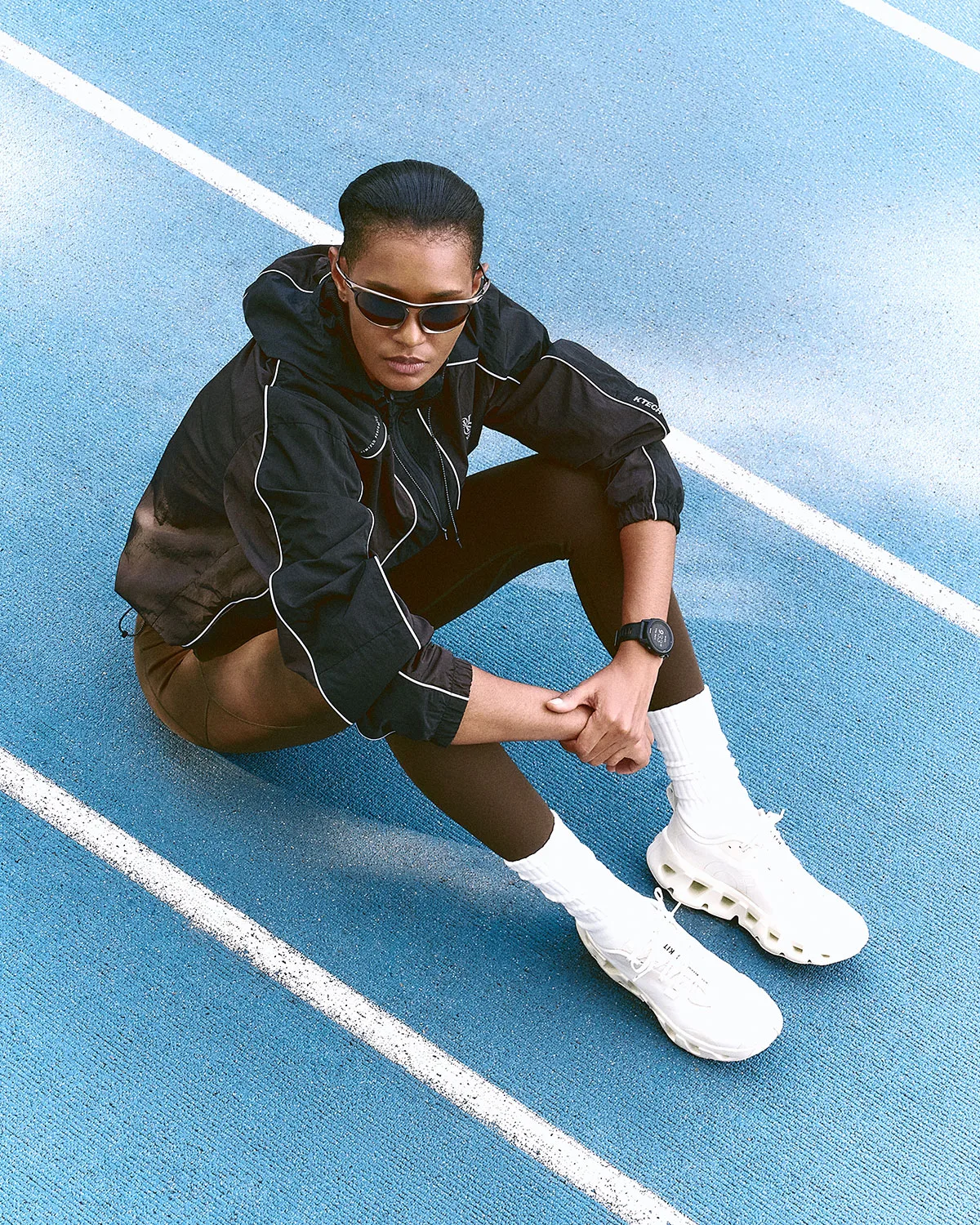 on-foot, seated on blue track wearing white pair with cutout midsole, K Tech 3