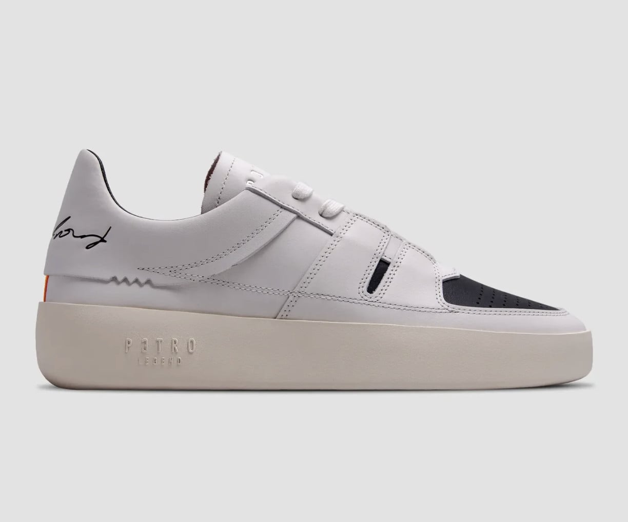 Lateral view, white leather upper with black toe panel, black signature logo, P3TRO Legend