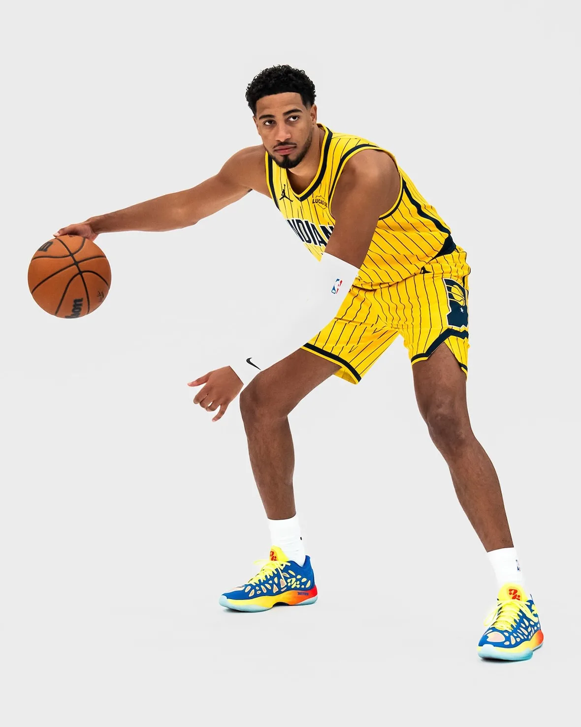 on-foot side view mid-dribble, blue and yellow cutout shoes with translucent icy outsole, Thermal Vision