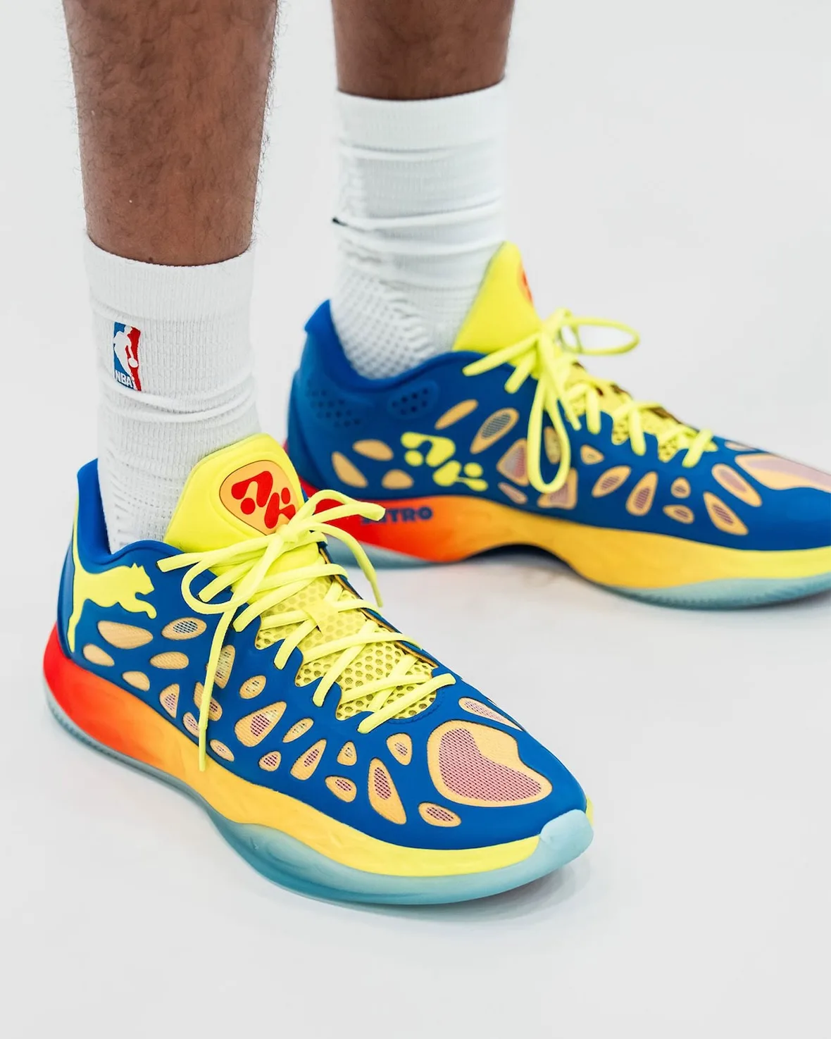 on-foot medial close-up, blue cutout upper, yellow laces, orange-to-yellow gradient midsole, Thermal Vision