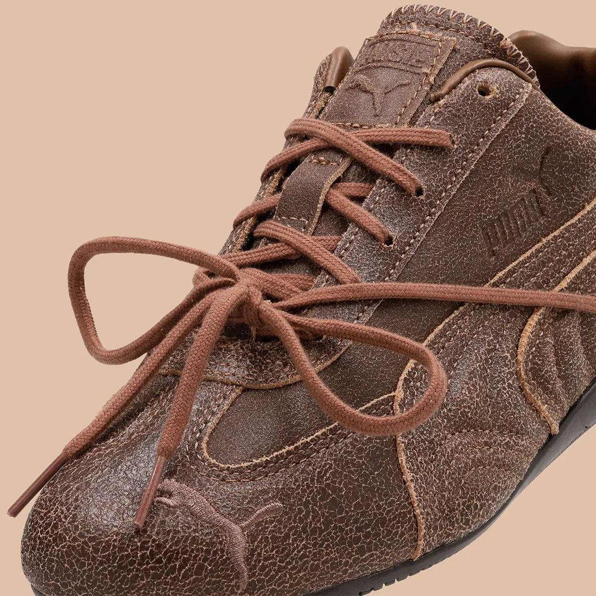 close-up of bow-tied laces on crackled brown leather with rosie tag, OG x Rosé