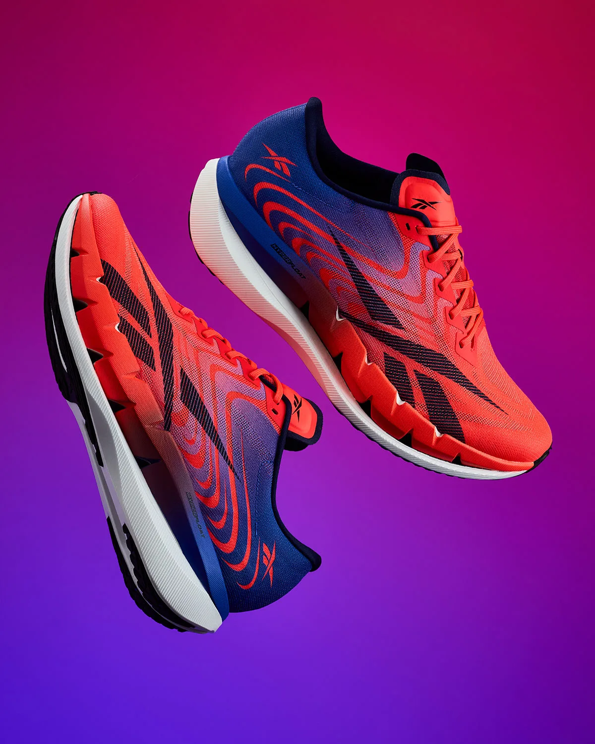 pair floating against pink-purple gradient, lateral and outsole angle views, Reebok SpeedShifter