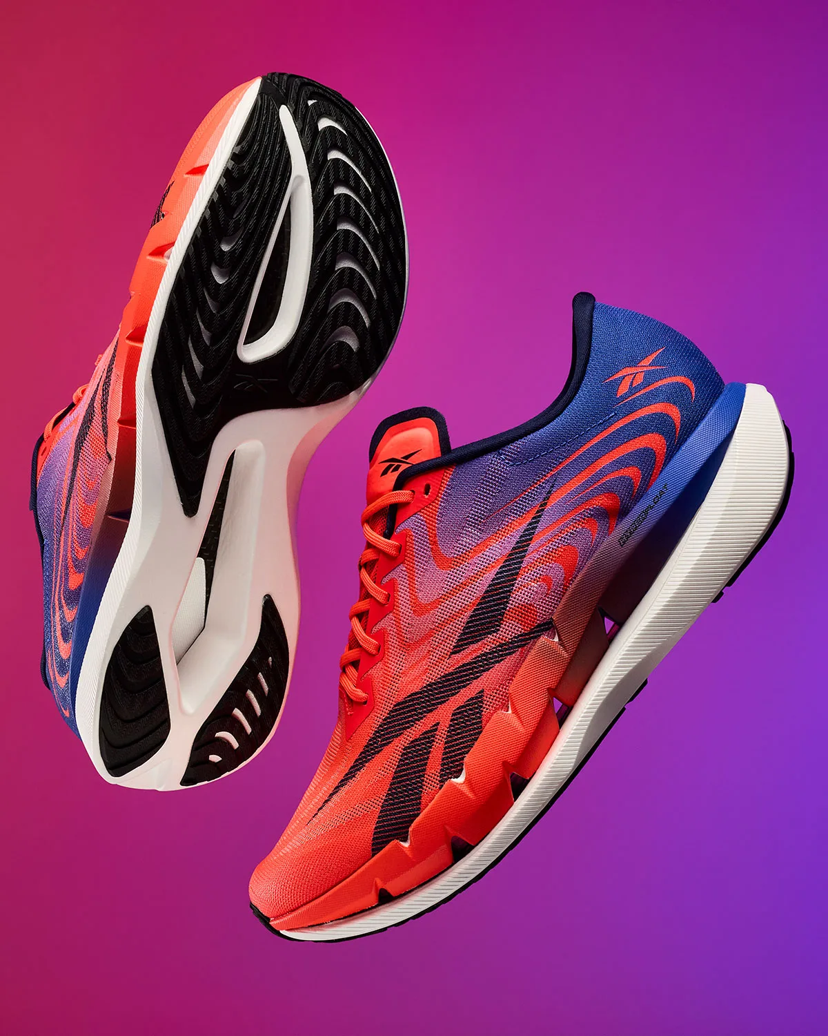 pair floating, one shown sole-up revealing black and white tread pattern, Reebok SpeedShifter