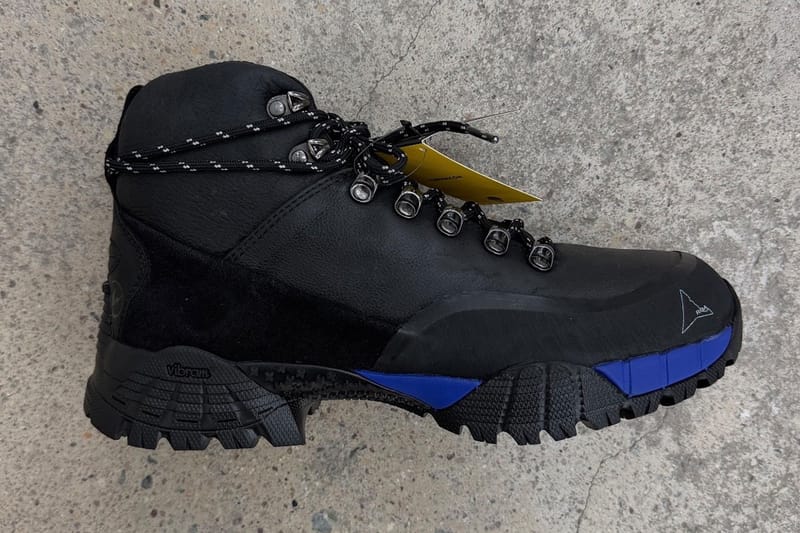 Lateral view with yellow Vibram hangtag on laces, black boot with blue sole trim, design Andreas Boot