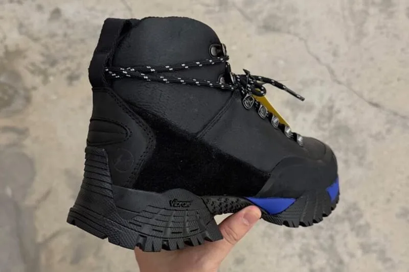 Heel view in-hand, black boot with blue midsole and Vibram outsole tread, design Andreas Boot