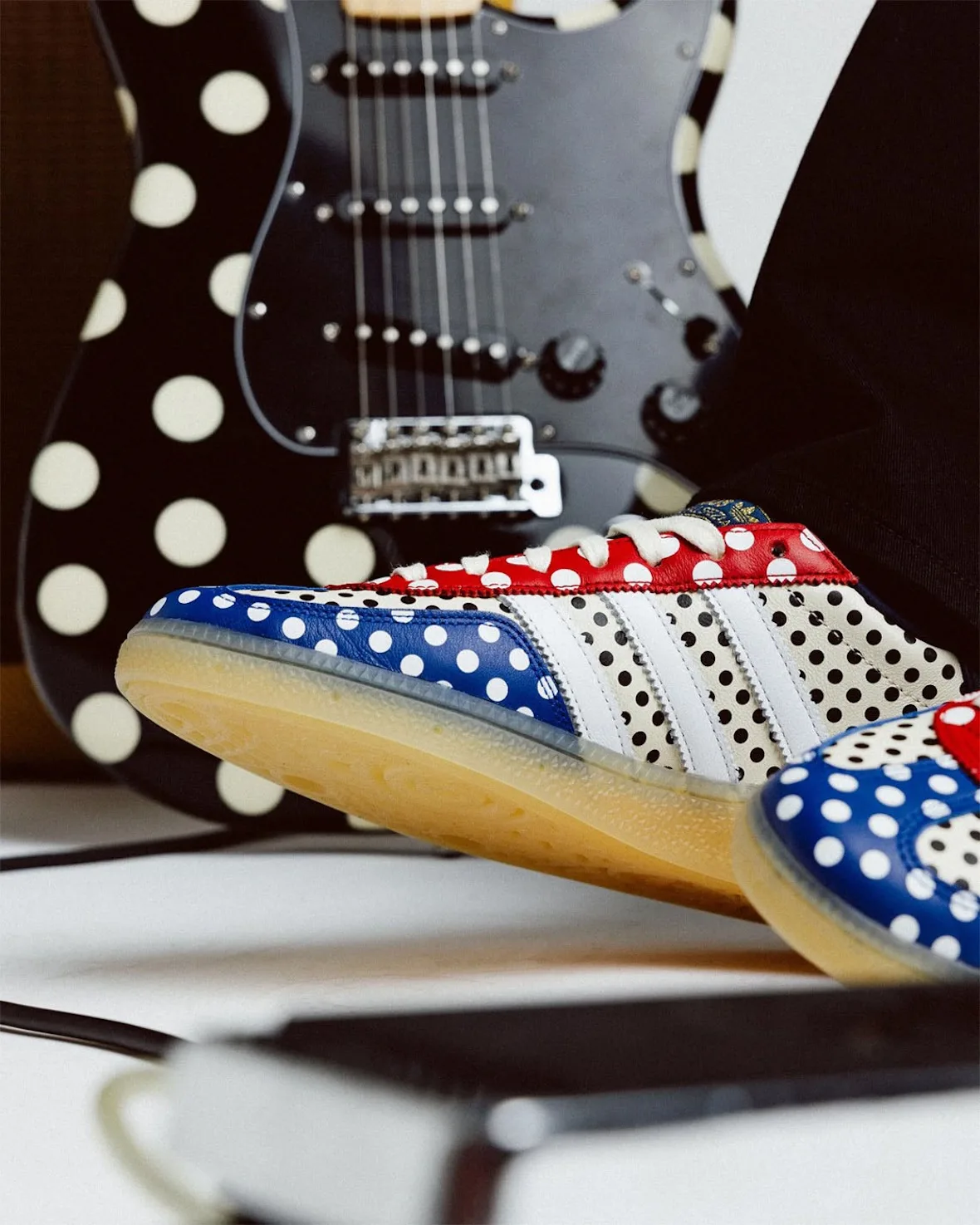 low-angle detail on outsole edge, blue polka-dot toe, gum sole, guitar behind, Polka Dot