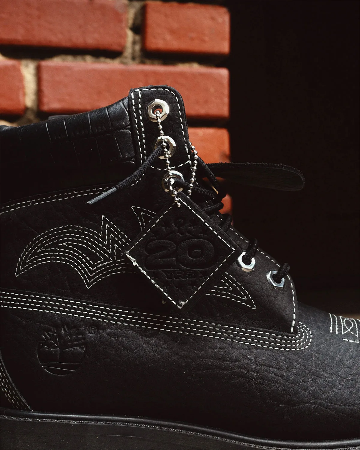 close-up of black boot collar, eyelets and embossed 20-year leather tag, x Sneaker Politics