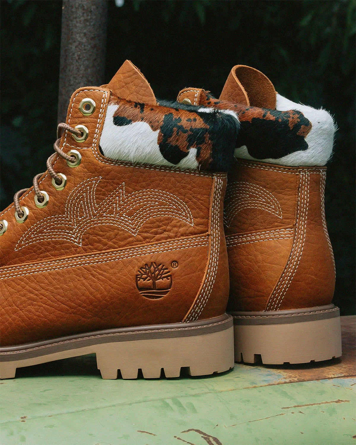 heel close-up of wheat pair, cow-print pull tabs, tree logo, gum sole, x Sneaker Politics