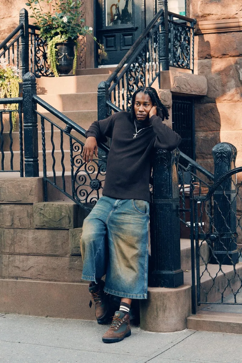 on-foot full body, man leaning on brownstone stair railing, Timberland Field Boot