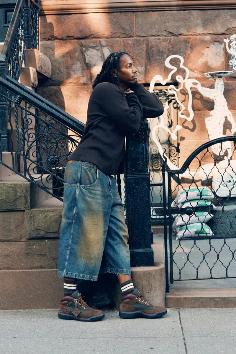 on-foot side profile, man leaning against ironwork gate post, Timberland Field Boot