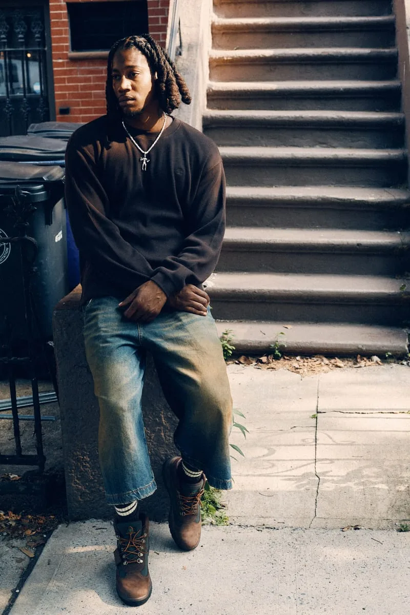 on-foot full body, man seated on stone ledge near brownstone steps, Timberland Field Boot