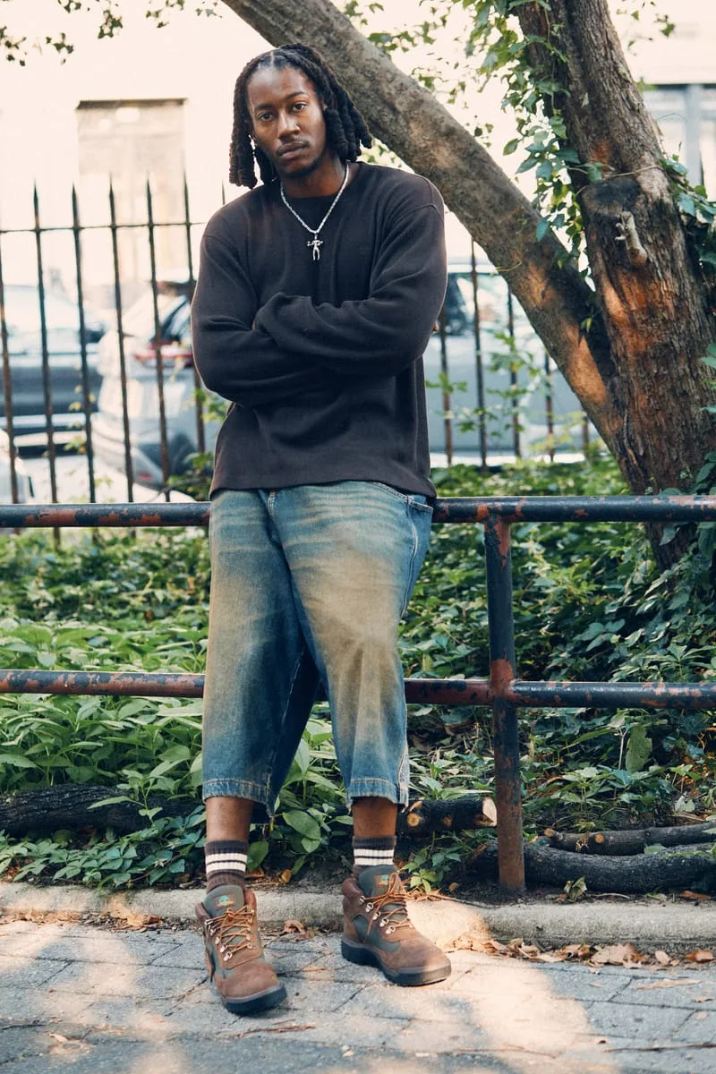 on-foot full body, man leaning on railing beside tree-lined street, Timberland Field Boot