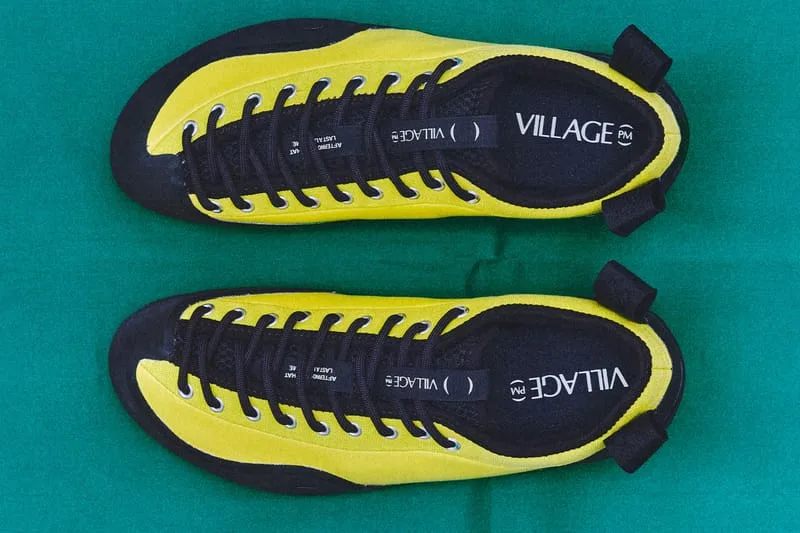 top-down pair view, yellow-black shoes with VILLAGE PM branding on insoles, VILLAGE PM 2PM