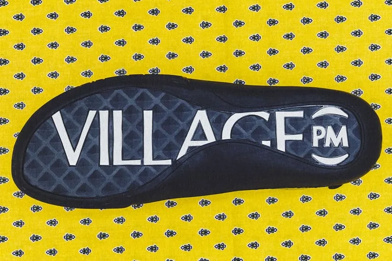 outsole close-up, black sole with VILLAGE PM text on yellow patterned fabric, VILLAGE PM 2PM