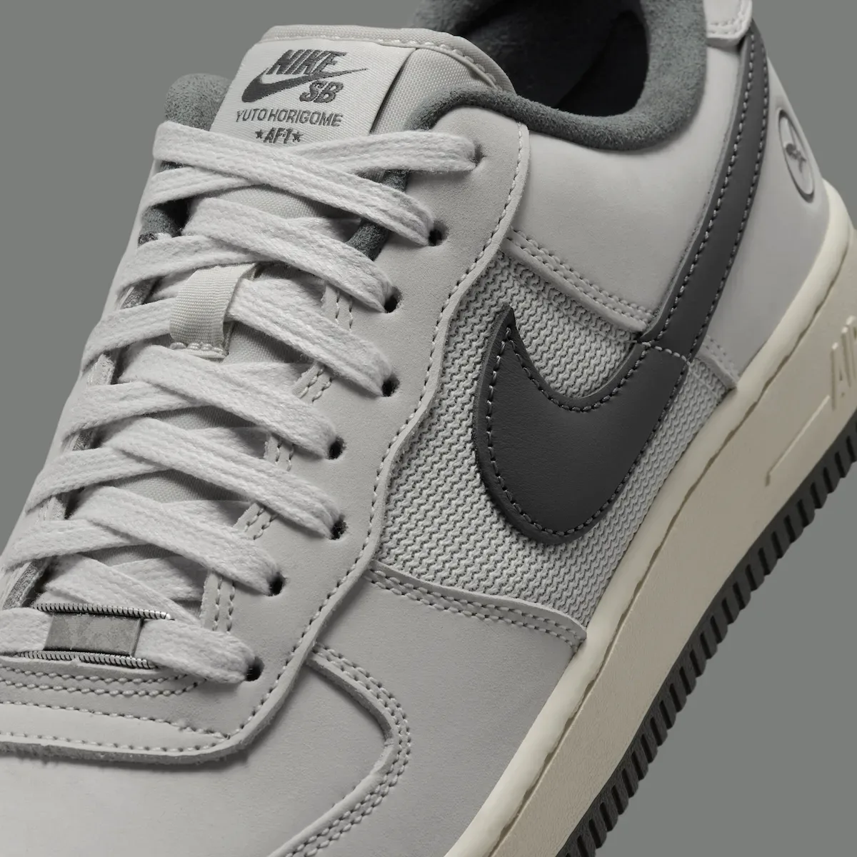 close-up tongue tag reading Nike SB Yuto Horigome AF1 beside dark swoosh, Iron Grey