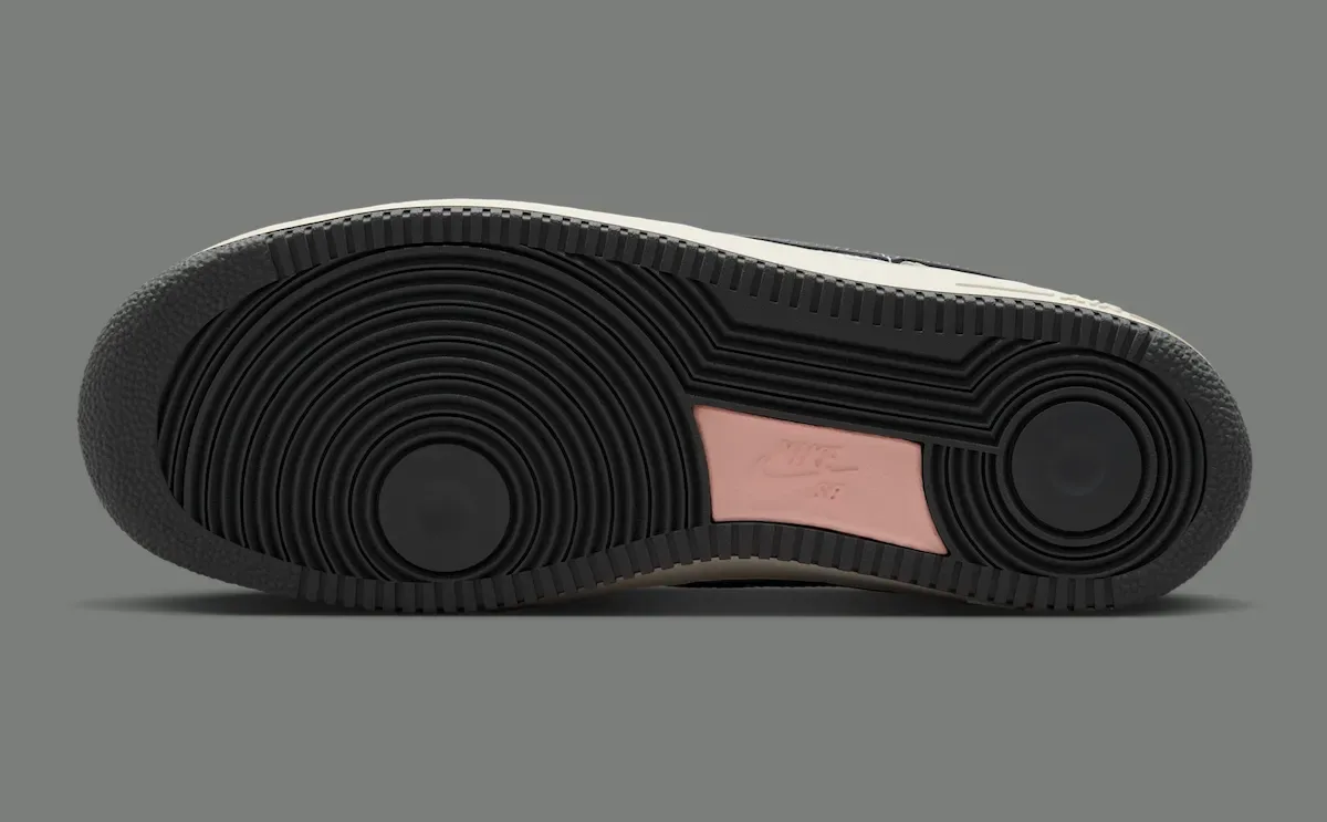 outsole in profile, black tread pattern with a pink Nike Air heel patch, Iron Grey