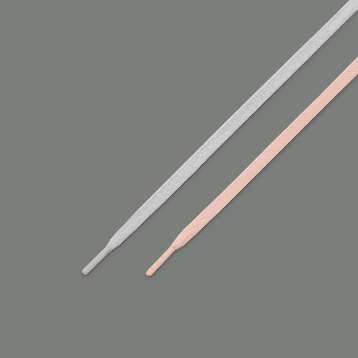 detail of two laces crossed diagonally, one white, one pale pink, Iron Grey