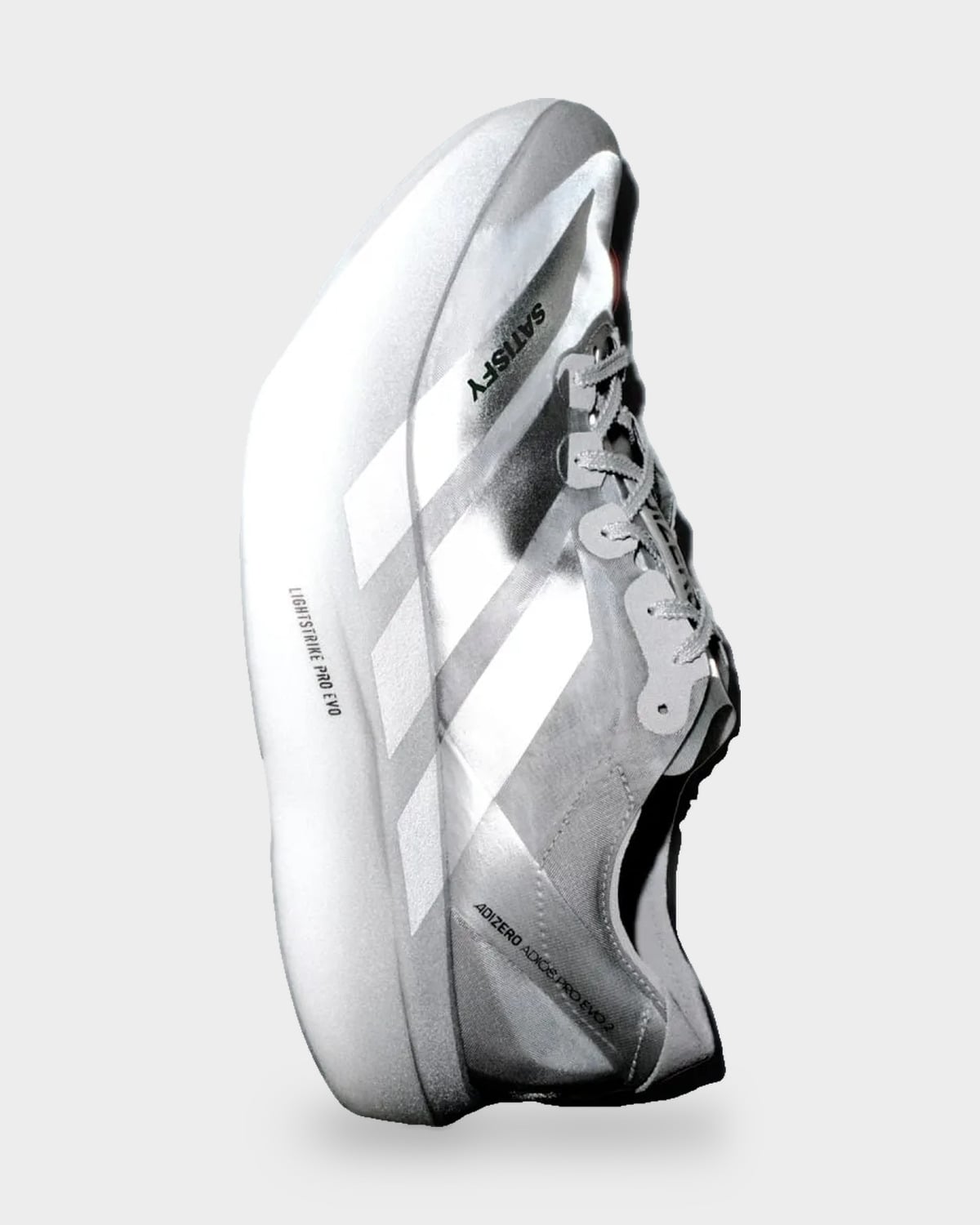 Tilted lateral view of silver shoe with white stripes and SATISFY text on upper, 2 x Satisfy