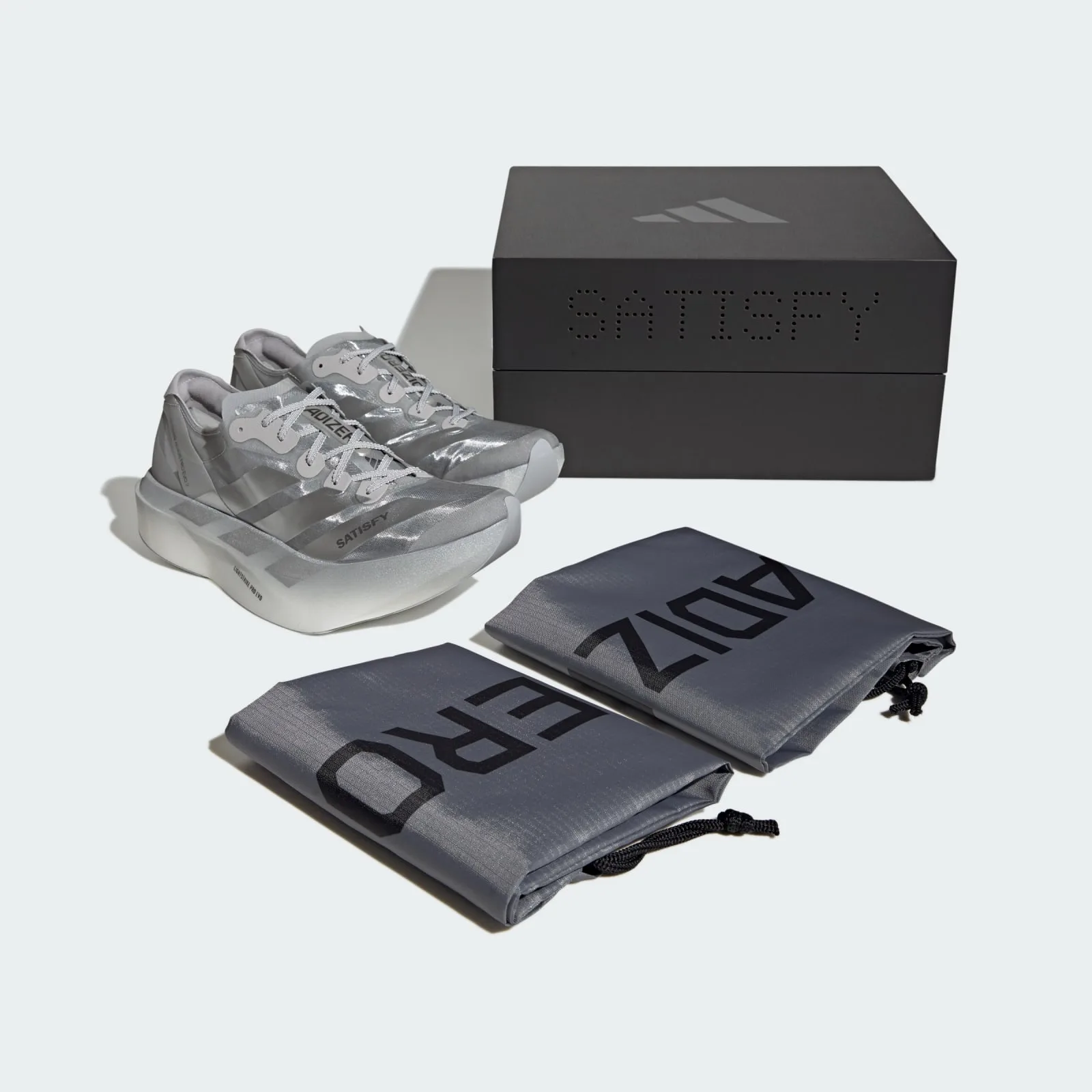 Pair with black SATISFY box and two grey ADIZERO drawstring bags, 2 x Satisfy