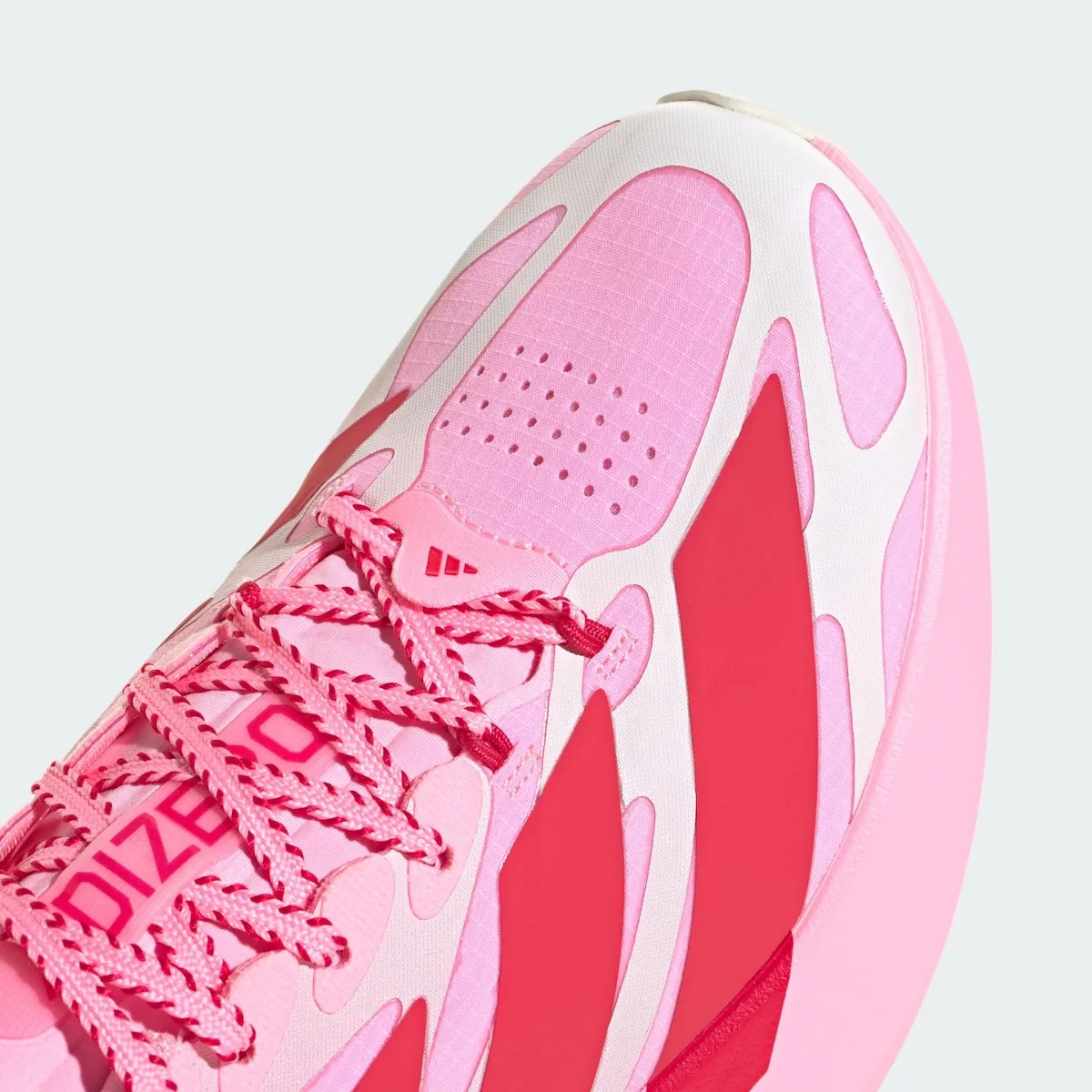 Toe-box detail of pink ripstop mesh with perforations, white overlays, red stripes and striped laces, Pink Glow Hearts