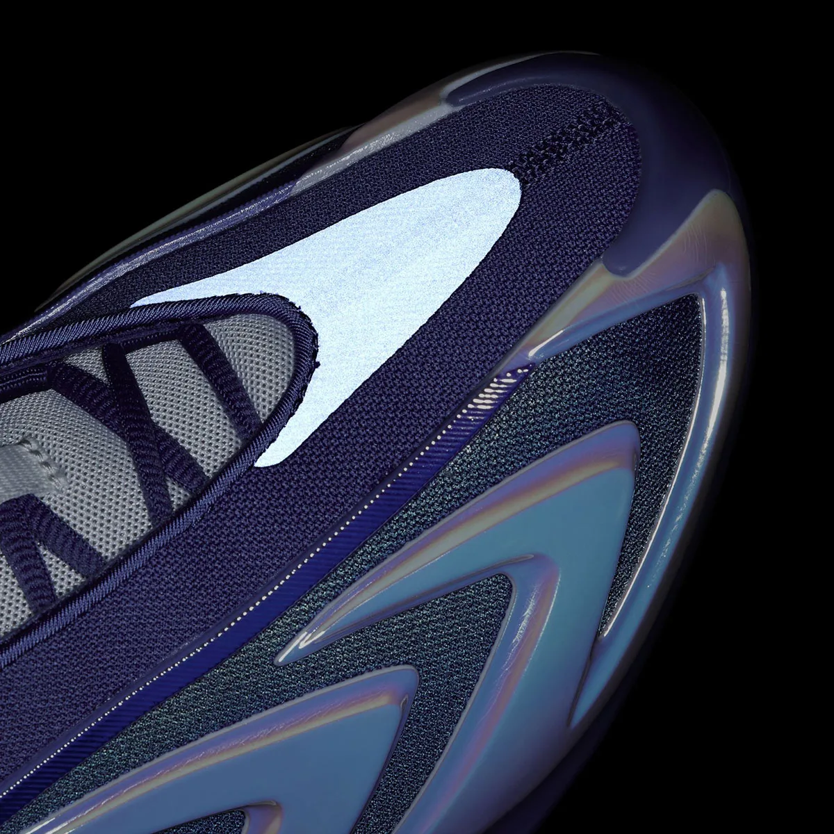 Detail of toe box on black background with a bright reflective panel and dark blue iridescent overlays, Purple Iridescent