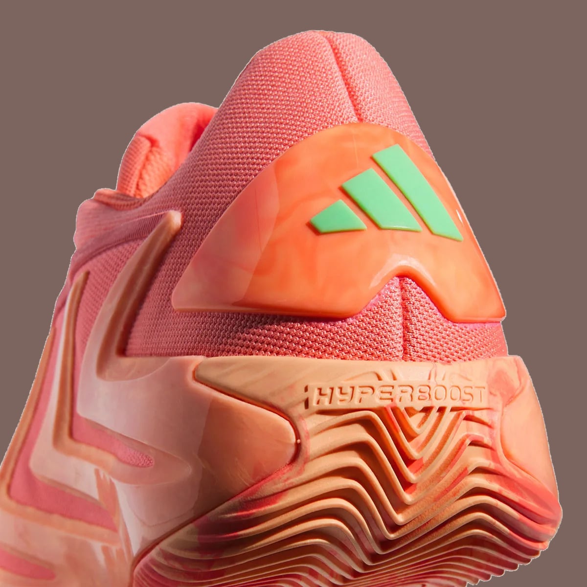 Heel detail, green three-stripe logo on orange clip, Hyperboost text on peach midsole, With Love