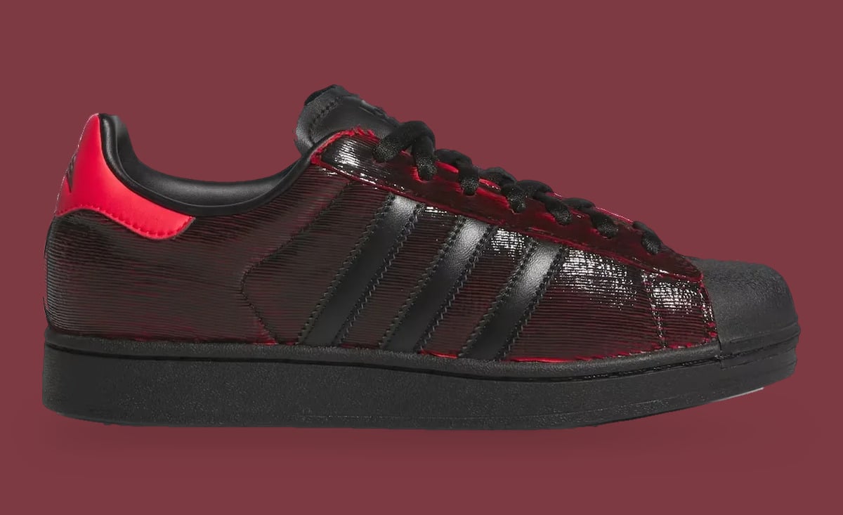 Medial view, black three stripes on glossy ridged black-red upper, red heel tab, black sole, Halloween