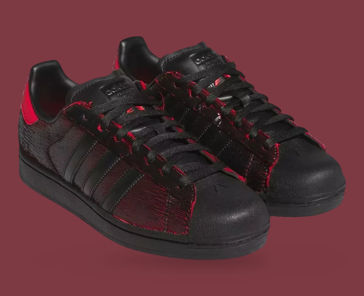 Pair, three-quarter view: black shell toes with small logos, black laces, red-edged ridged panels, Halloween