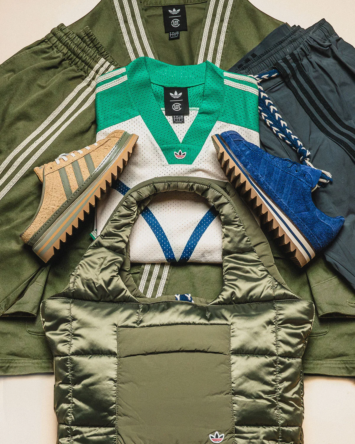 Flat lay of tan and blue shoes with green mesh jersey, olive jacket, grey shorts and quilted tote, Mule x CLOT