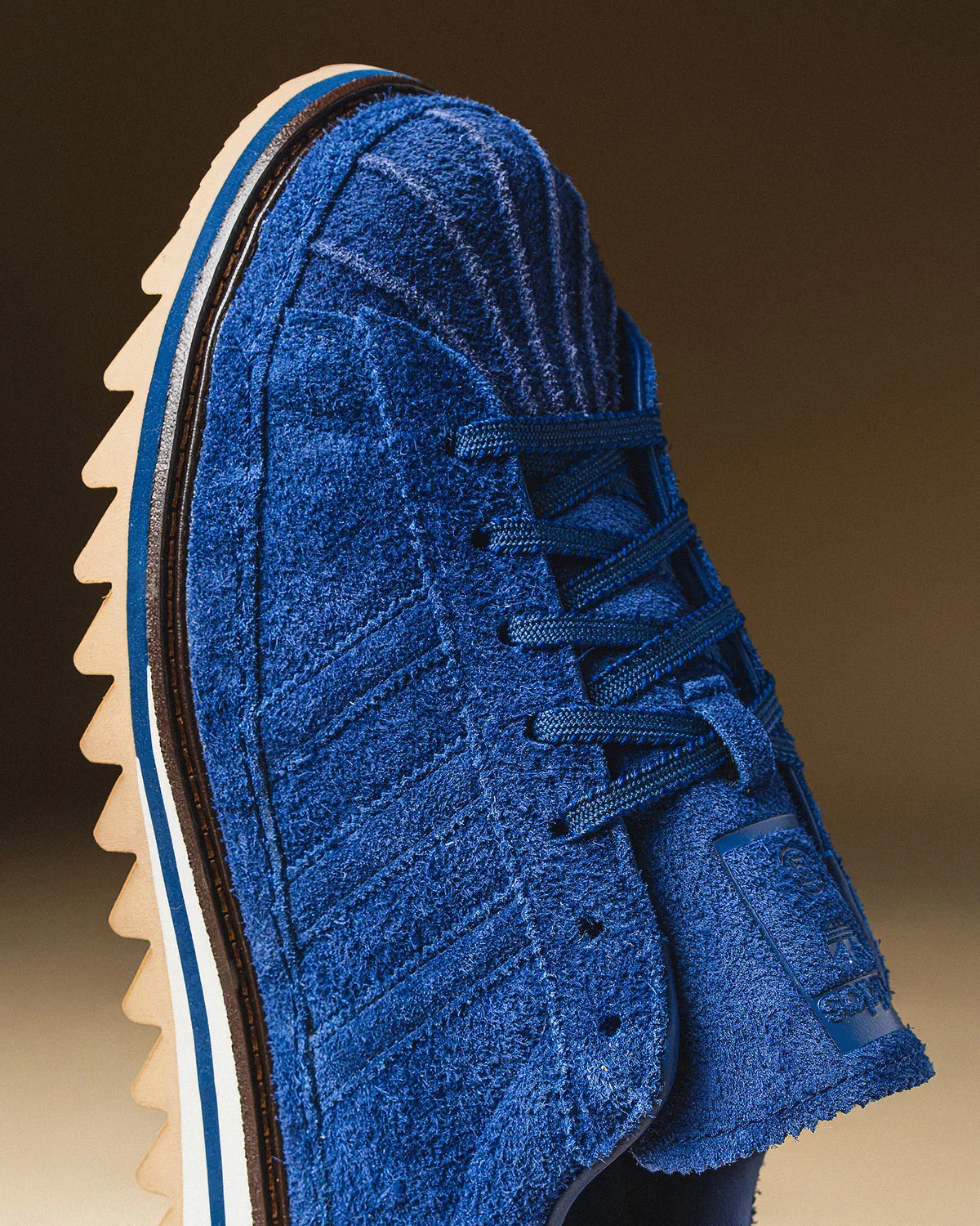 Detail of blue shaggy suede toe and three stripes, with navy laces and sawtooth cream sole, Mule x CLOT