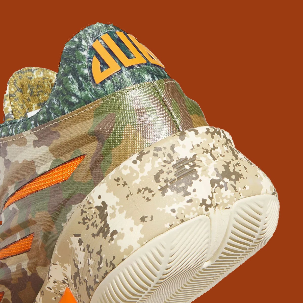 Heel detail with orange lettering on green tab, camo midsole and cream outsole tread, What The Camo