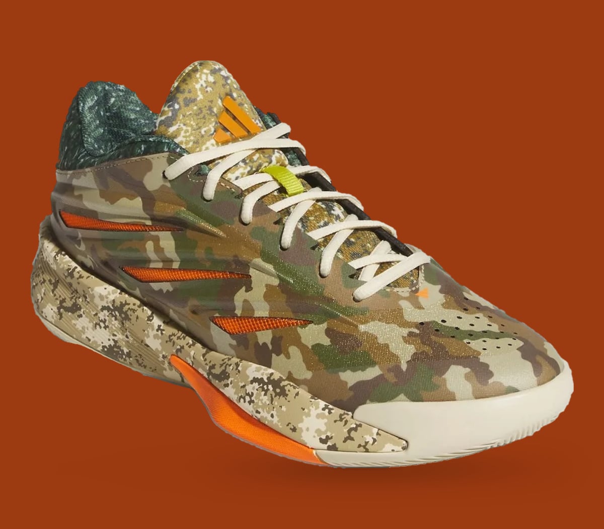 Front three-quarter view with cream laces, lime lace loop and orange logo on tongue, What The Camo