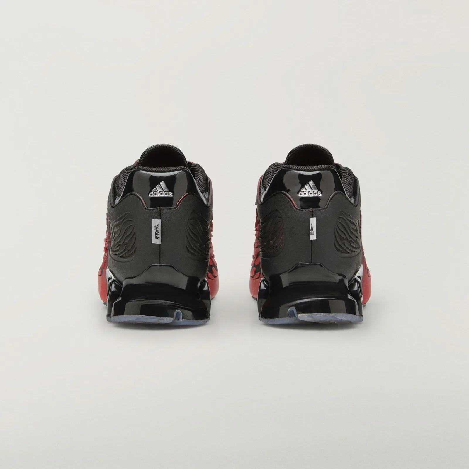 Heel view of pair, black glossy counters with silver adidas logos and small white tags, Red/Black