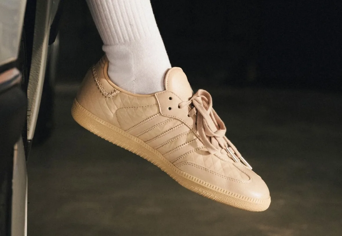 On-foot lateral view of a tan quilted-leather sneaker with white sock and silver lace tips, x Mercedes Benz