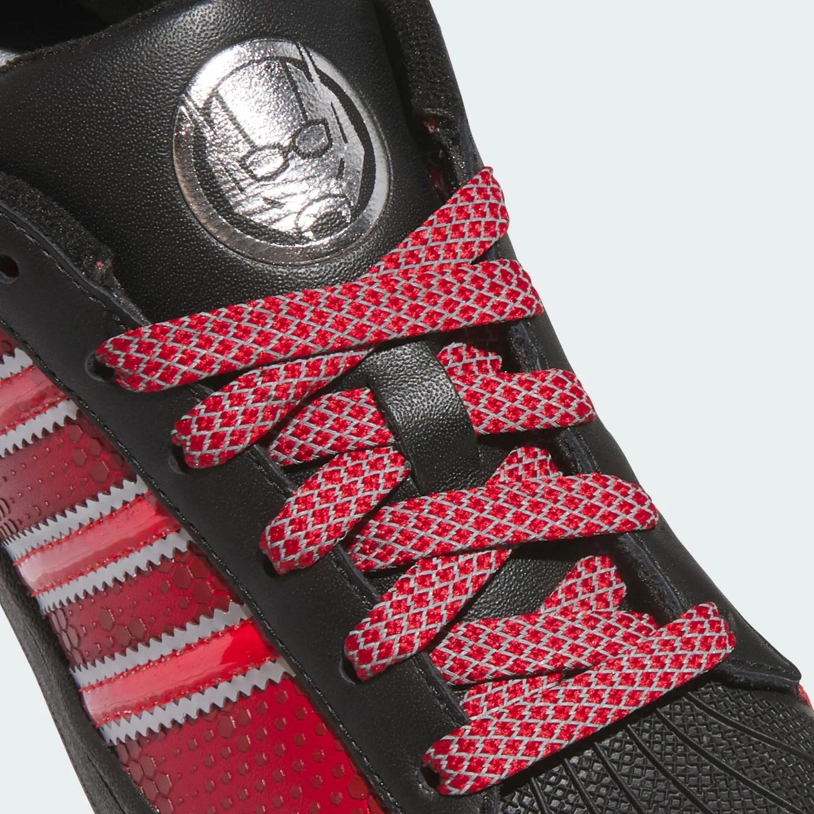 Tongue detail with a silver Ant-Man emblem and red lattice-patterned laces, Ant Man