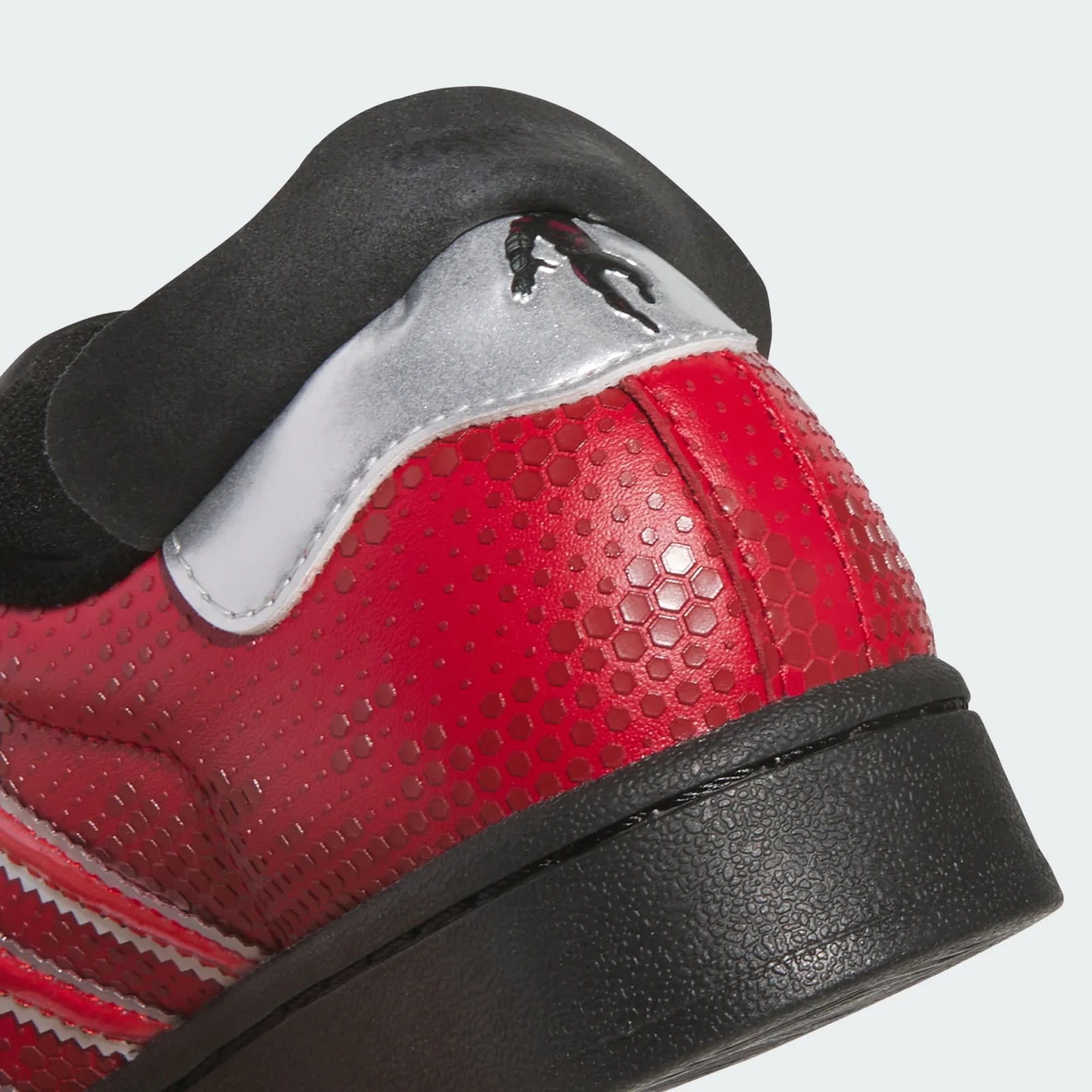 Heel detail with red hexagonal texture and a tiny figure on the silver tab, Ant Man