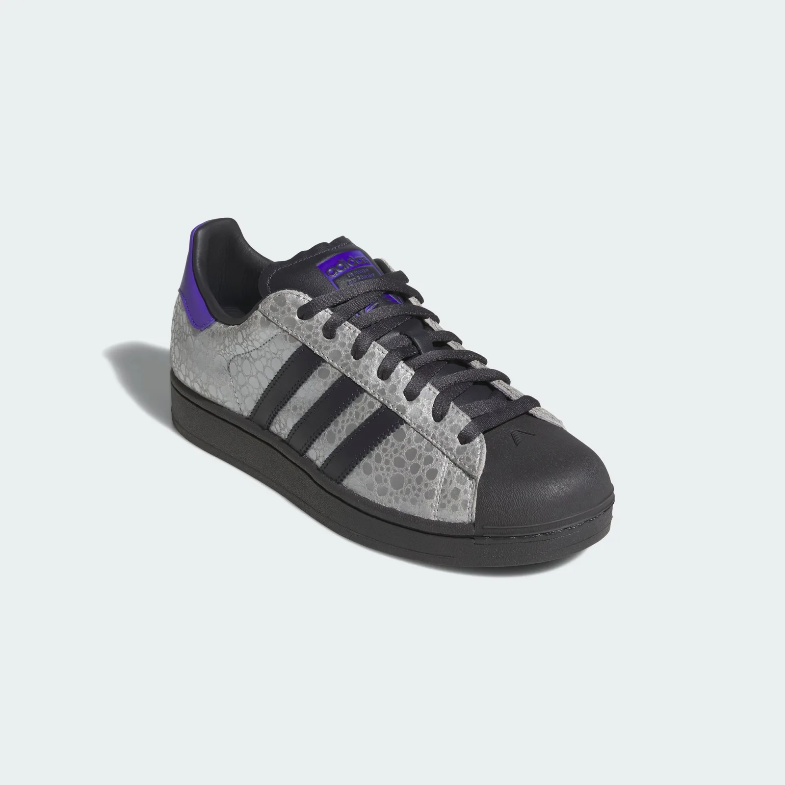 angled toe view, black toe cap, silver cracked texture, purple heel tab visible, Stone
