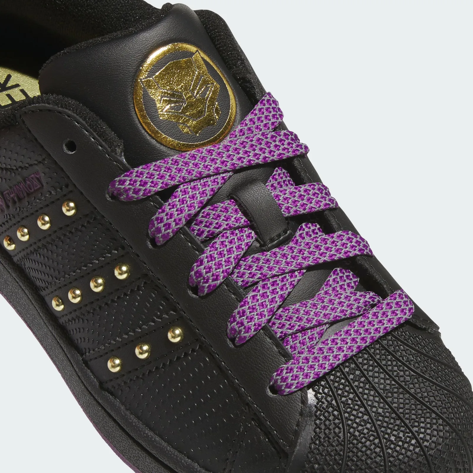 Tongue detail with a gold Black Panther logo and purple patterned laces, Black Panther
