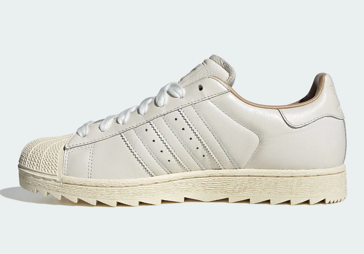 Medial view with off-white leather, serrated three stripes, cream shell toe and sawtooth sole, Core White