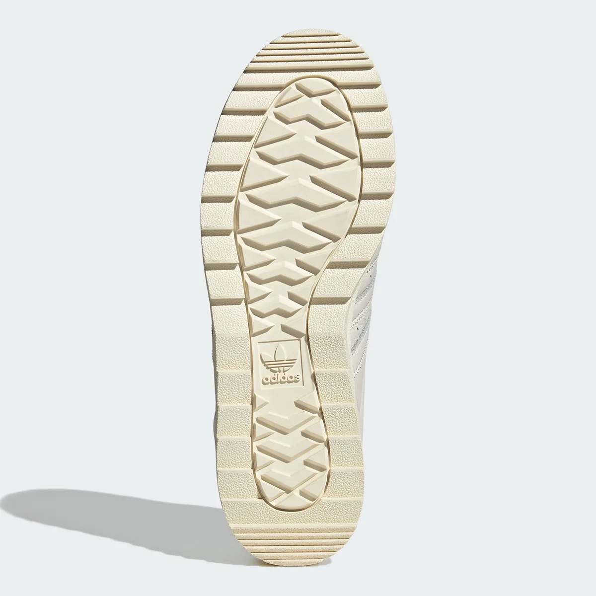 Outsole view with cream chevron tread pattern and embossed adidas trefoil logo, Core White