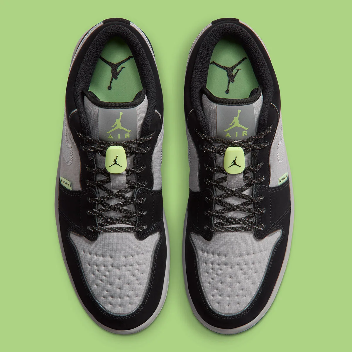 Top-down view of a pair with green insoles, Jordan logos, neon green lace toggles and black laces, Light Smoke Grey