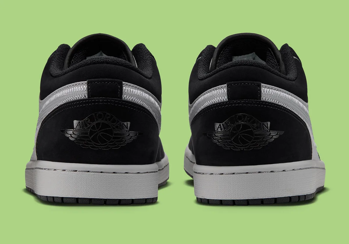 Heel view of a pair with black nubuck heels, embossed Air Jordan wings logos and grey midsoles, Light Smoke Grey
