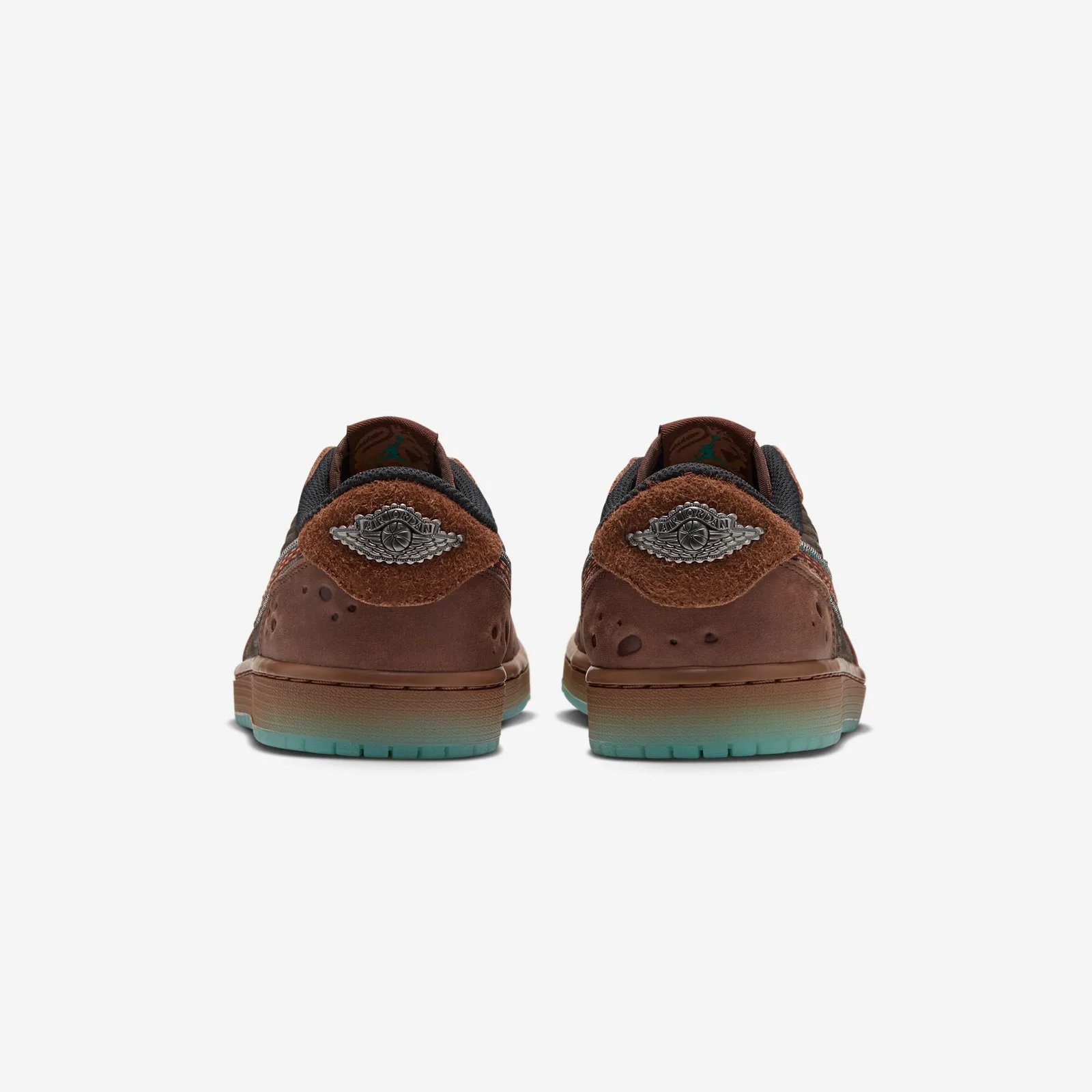Heel view of pair, shaggy brown heel tabs with silver Air Jordan wings logo, icy teal soles, Somos Historias