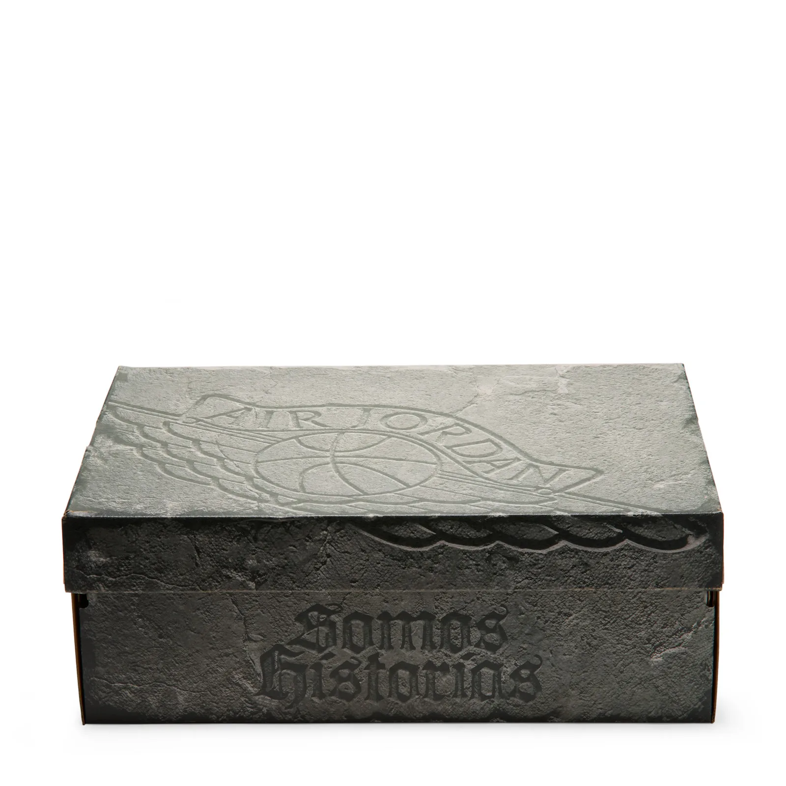 Closed stone-textured grey box, embossed wings logo on lid, Somos Historias on side, Dia de Los Muertos