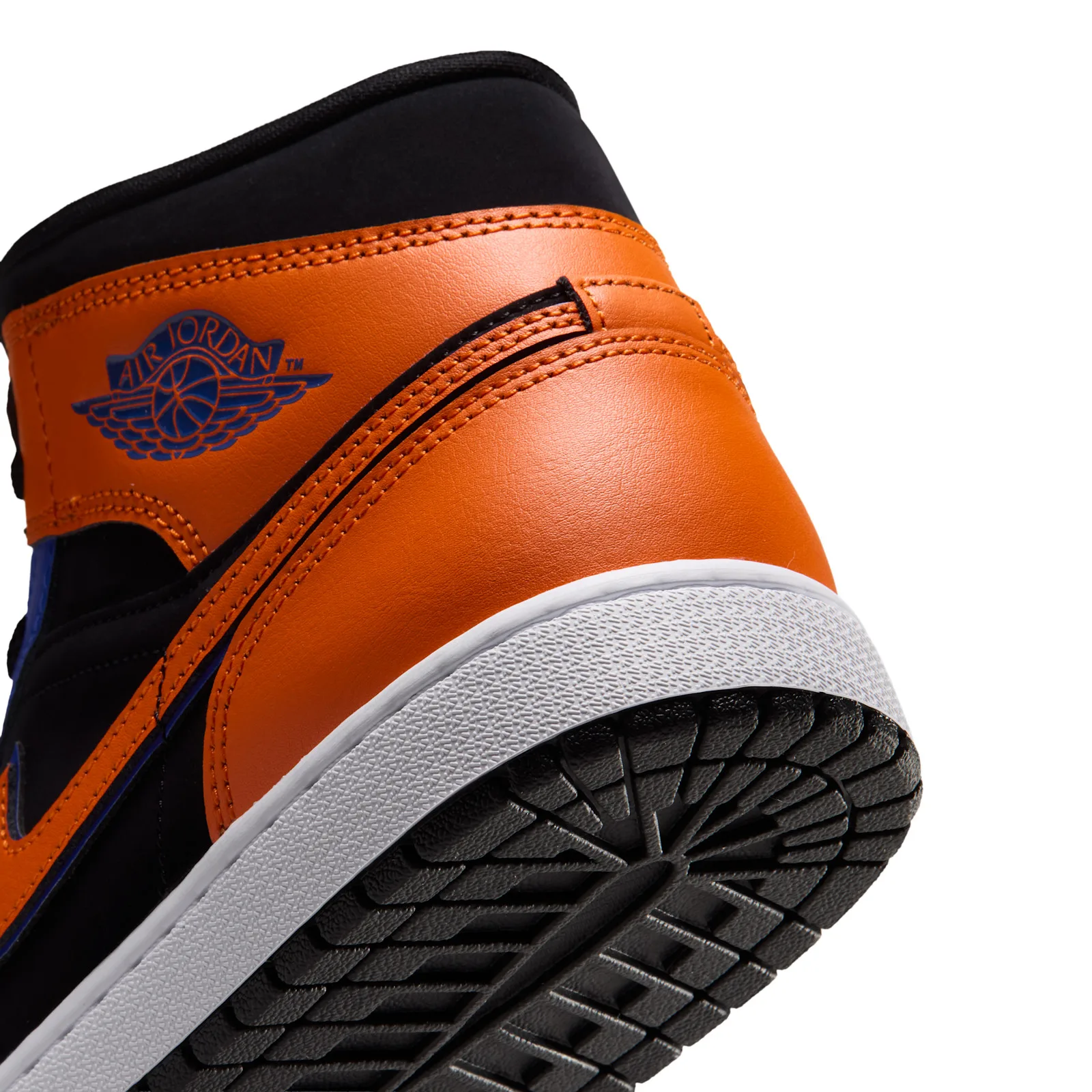 Heel detail, blue Air Jordan wings on orange leather, black tread, white background, Knicks