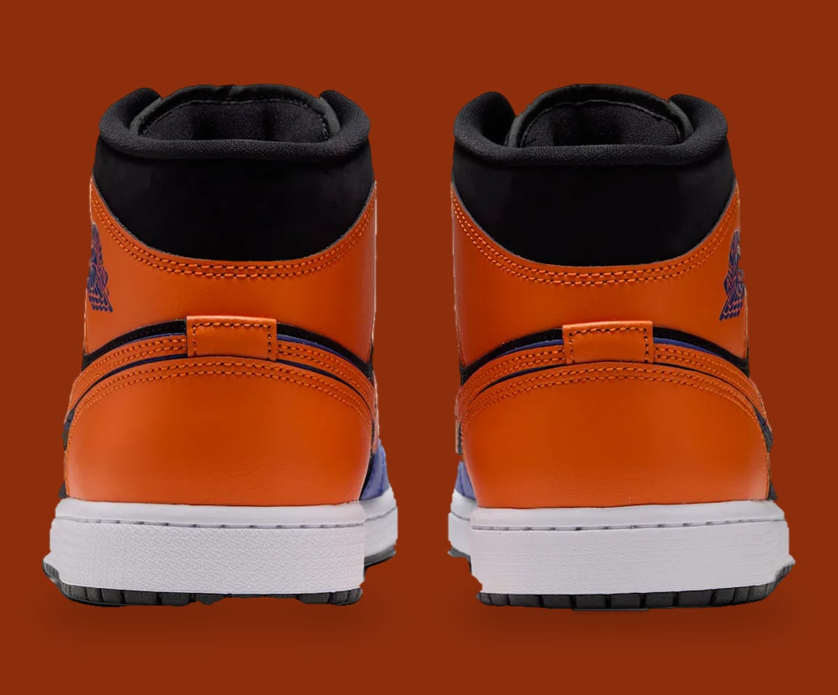 Heel view of pair, orange heel panels, black collars, white midsole, rust backdrop, Knicks