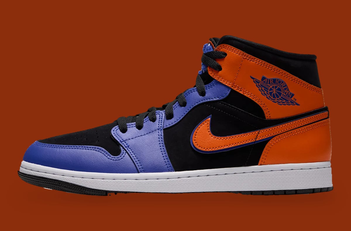 Lateral view, orange swoosh and Air Jordan wings logo on black upper, rust backdrop, Knicks